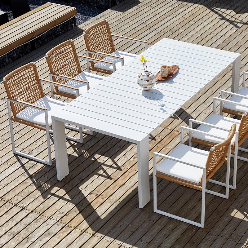SUNRISE white outdoor dining table styled with outdoor dining chairs on a deck