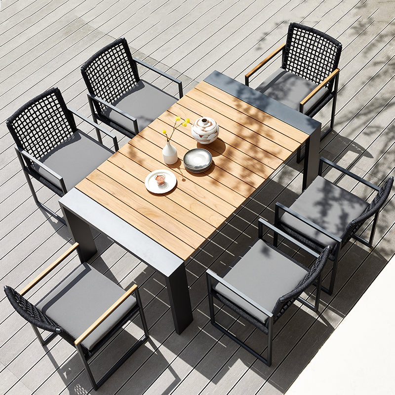 SUNRISE teak outdoor dining table styled with dark woven outdoor dining chairs