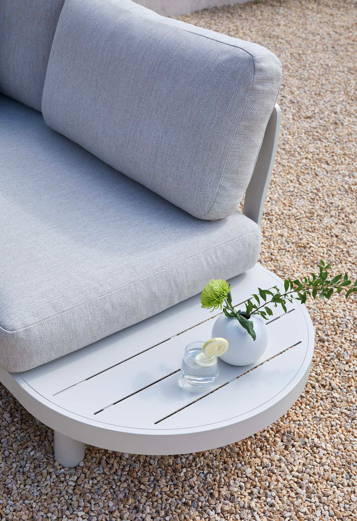 Detail of the white curved outdoor sofa with soft cushions