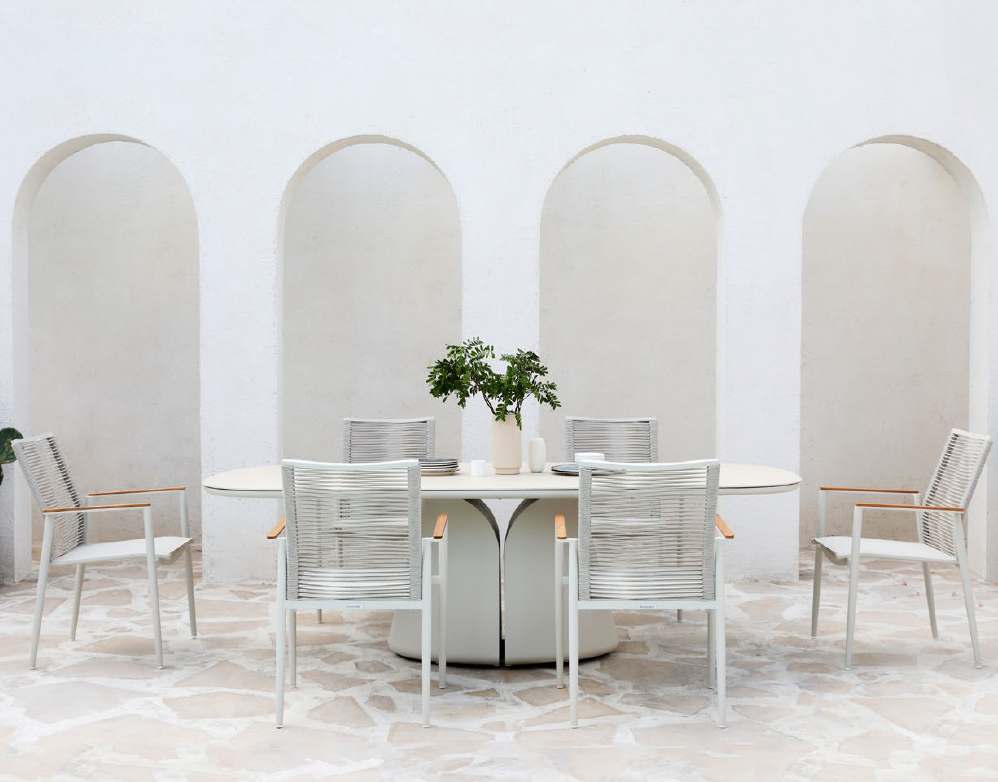 ALMA white outdoor dining set with woven armchairs beside a pool