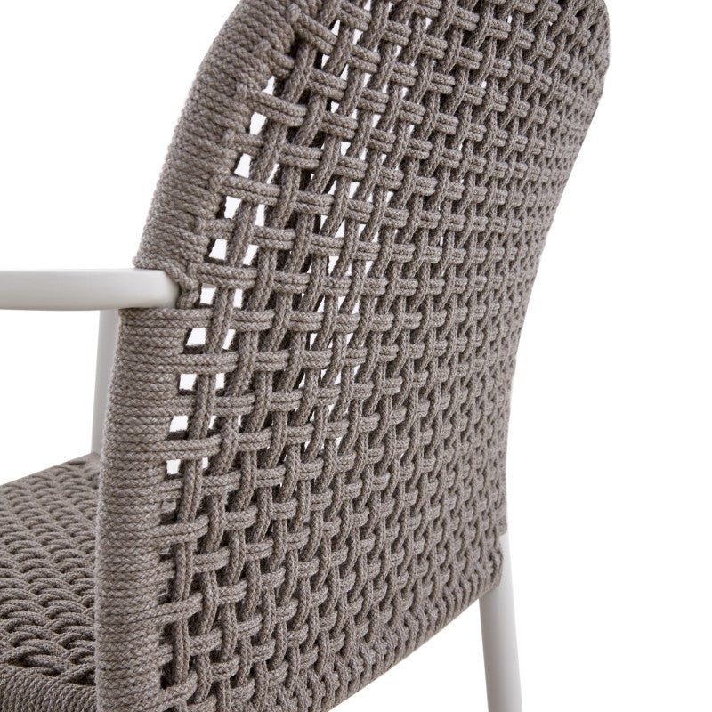 Angled view of the FANO grey woven outdoor dining armchair with white frame