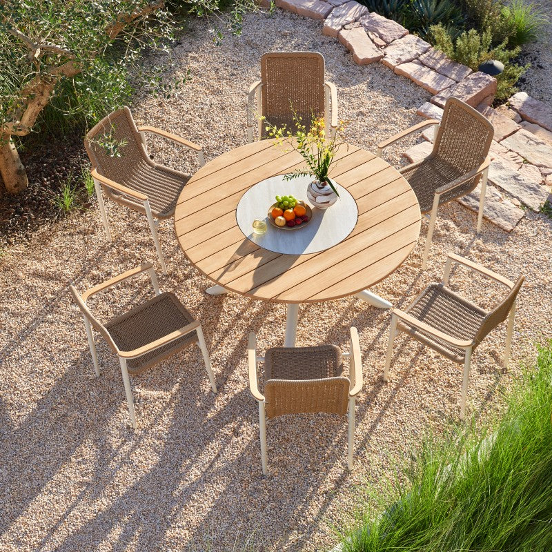 Styled detail of the LOOP teak outdoor dining table in an outdoor garden setting