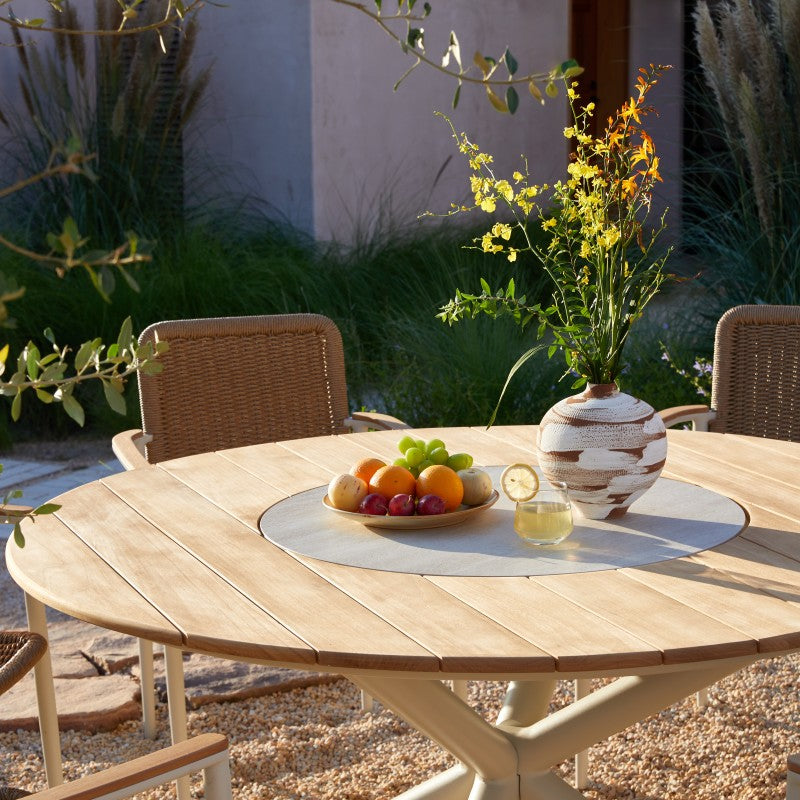 Front view of the LOOP teak round outdoor dining table with crossed pedestal base