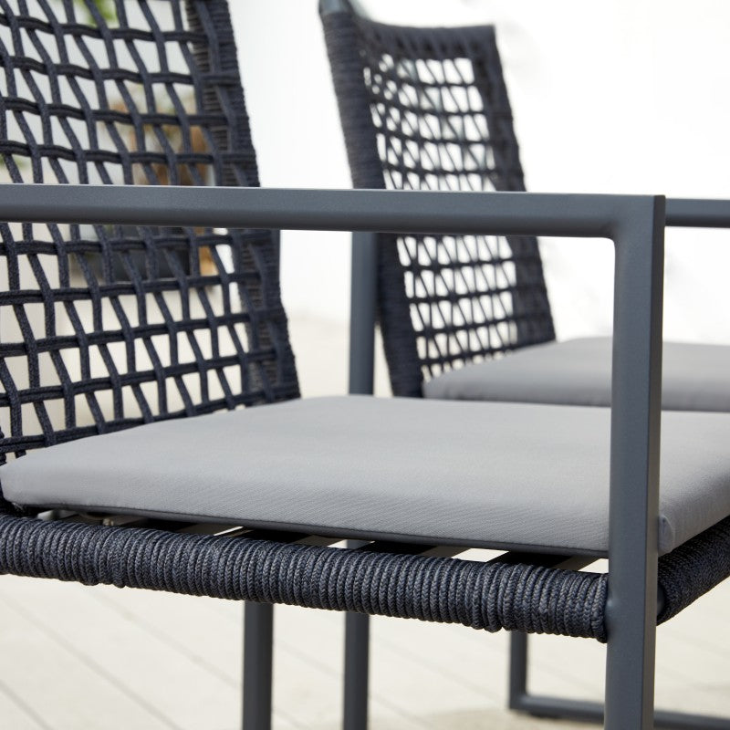 Front view of the SUNRISE black rope-woven outdoor dining armchair with light cushion