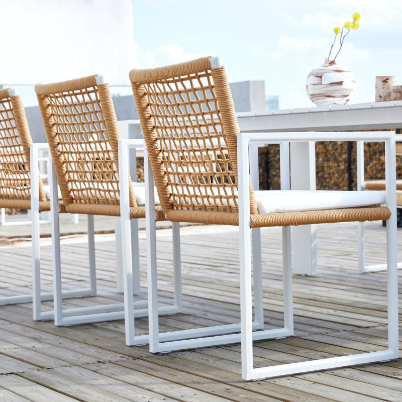 SUNRISE natural rope-woven outdoor dining armchair in an outdoor dining setting