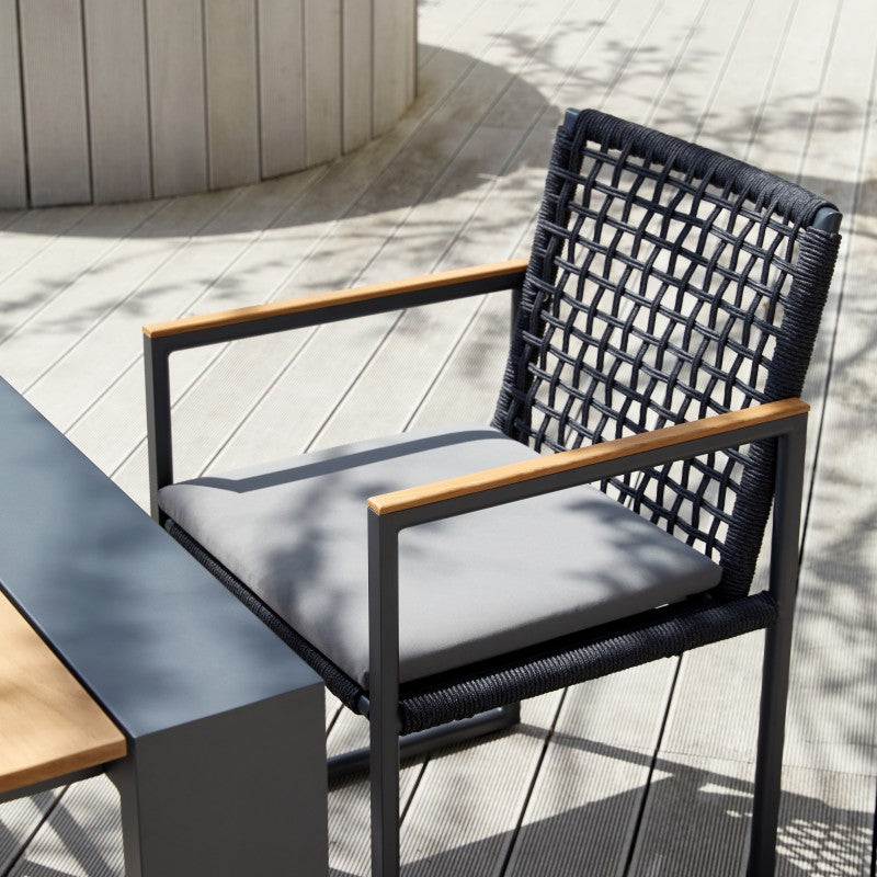 SUNRISE black rope-woven outdoor dining armchair arranged around an outdoor dining table