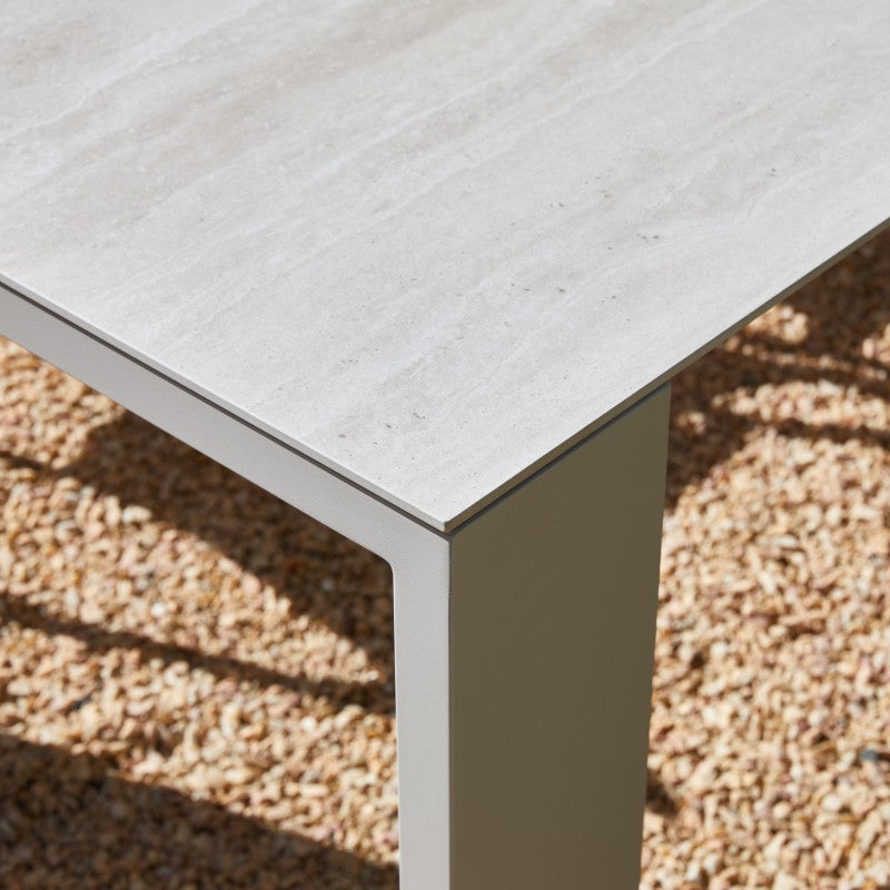 Close-up of the SUNRISE white outdoor dining table edge and straight leg