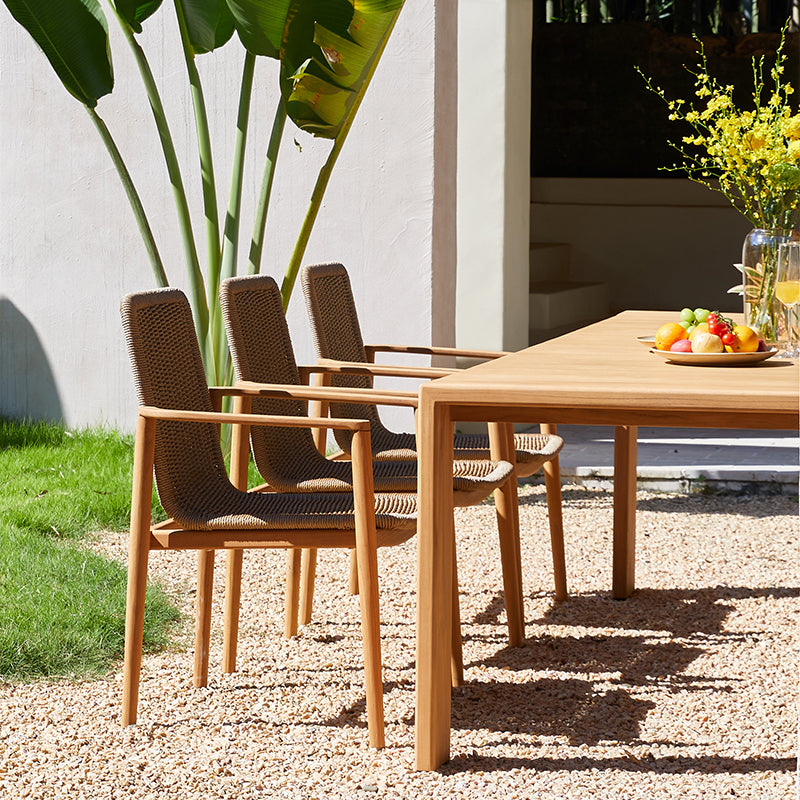 SUNRISE teak outdoor dining set styled with woven armchairs in a garden